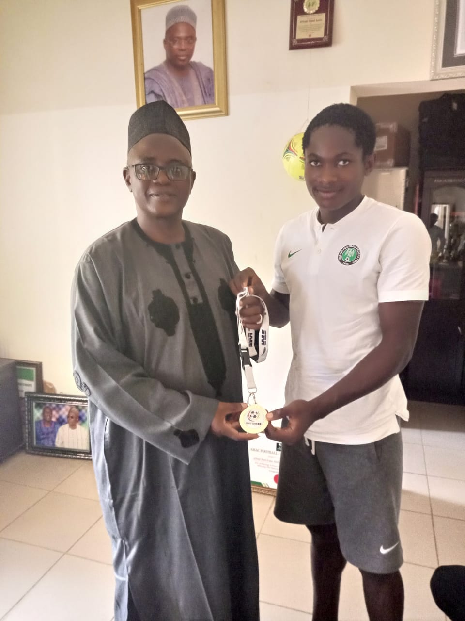Flying Eagles’ Midfielder, Ogbelu, Presents WAFU B Gold Medal To His School Boss, Sani Lulu