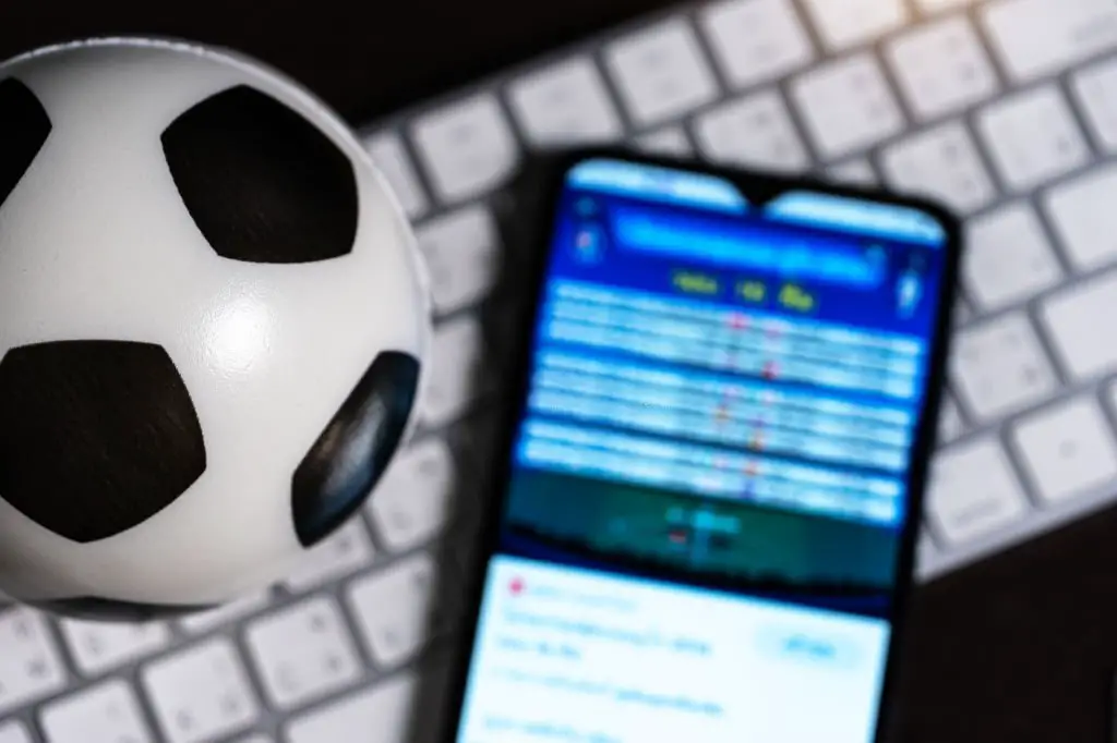 Homem com smartphone, jogador fazendo apostas de futebol. vício em jogos de  azar no celular, aplicativo de apostas esportivas, previsão de resultados  de partidas de futebol.